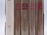 several books are lined up in a row on a white surface