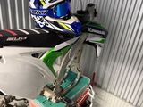 une moto tout-terrain garée dans un garage, avec un casque posé dessus