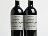 deux bouteilles de vin posées sur une table l'une à côté de l'autre