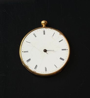 a gold clock with roman numerals on a black surface