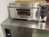 a small oven sitting on top of a metal counter