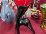 une table recouverte d'une nappe rouge et sur laquelle sont posés des vases