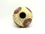 a white and brown vase with a flower design on it