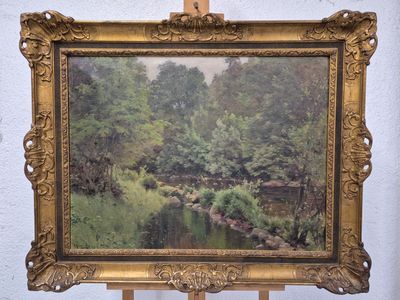 tableau sur chevalet représentant une rivière et des arbres