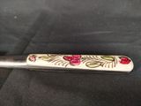 a knife with a floral design on it on a black cloth