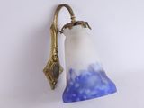 une applique murale dotée d'un abat-jour en verre bleu et blanc