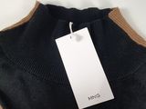 a person holding a tag on a sweater with a tag attached to it