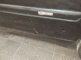a black suitcase sitting on the floor next to a car