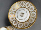 a cup and saucer sitting on a table next to each other