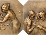 two bronze medals depicting a man and a woman with hands together