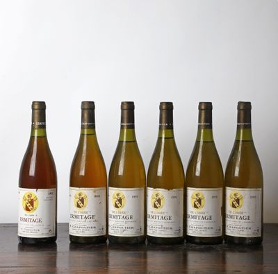 six bouteilles de vin sont alignées sur une table en bois