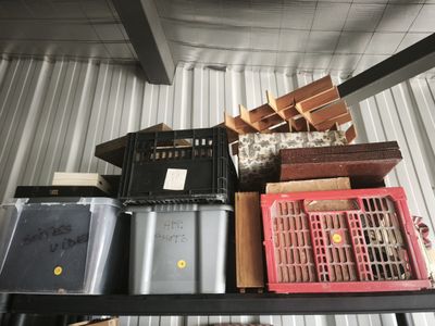 many boxes and crates sitting on a shelf in a room
