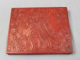 une vieille boîte rouge ornée de motifs complexes sur un fond blanc