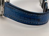 an image of a watch with a blue leather strap on a white surface