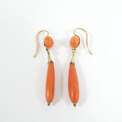 an image of a pair of orange earrings on a white surface