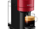une cafetière rouge avec une tasse de café à côté