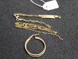 a gold necklace and a gold ring on a table