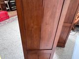 a tall wooden cabinet in the middle of a room