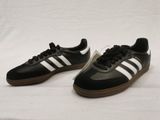 a pair of black and white adidas sneakers on a white background