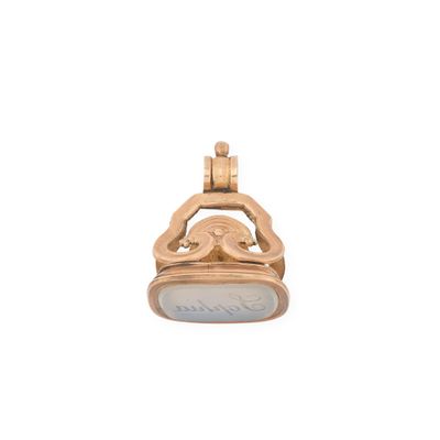 un gros plan d'un pendentif en or et nacre sur fond blanc