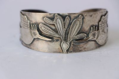 une image représentant un bracelet en argent orné d'un oiseau et de fleurs
