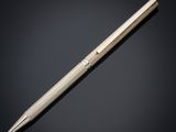 a silver ballpoint pen sitting on top of a black surface