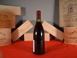 a bottle of wine sitting on a table next to wooden boxes