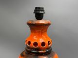 a large orange vase with holes on it