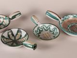 several different types of bowls and spoons on a white surface
