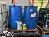 deux fûts bleus posés sur une palette dans un garage