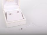 une boîte blanche contenant une paire de boucles d'oreilles en argent