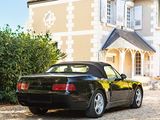 a black sports car parked in front of a large house