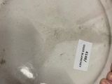 a person holding a plate with a sticker on it