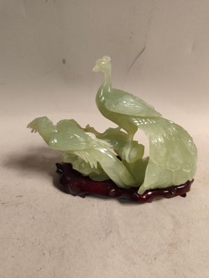 une figurine représentant un oiseau perché sur un fruit
