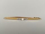a close up of a gold tie bar with pearls on it