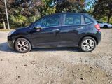 a picture of a small black car parked in a parking lot