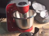 un mixeur rouge posé sur une table en bois