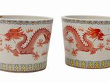 une paire de tasses rouges et blanches ornées de motifs représentant des dragons