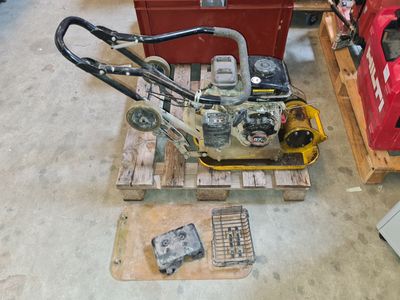 a small lawn mower sitting on a pallet in a garage