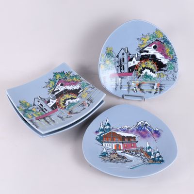 trois assiettes ornées de motifs, posées sur une surface blanche
