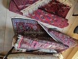 several pieces of oriental rugs are arranged on a wooden floor