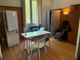 une table et des chaises dans une pièce équipée d'un réfrigérateur