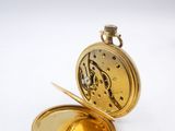 an image of a gold pocket watch sitting on top of a white surface