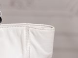 a white purse with a chain hanging from it ' s side