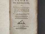 an old book opened on a table with a black background
