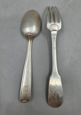 deux cuillères en argent et une fourchette posées sur une table