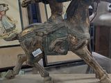une statue représentant un homme à cheval posée sur une table en verre