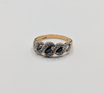 gros plan d'une bague en or avec une pierre bleue