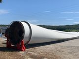 a large wind turbine sitting in the middle of a field