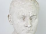 marble bust of a young boy with short hair and no shirt